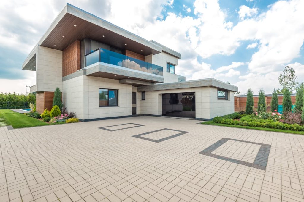 pexels-photo-8134845 Elegant modern house exterior with lush greenery and ample driveway space.